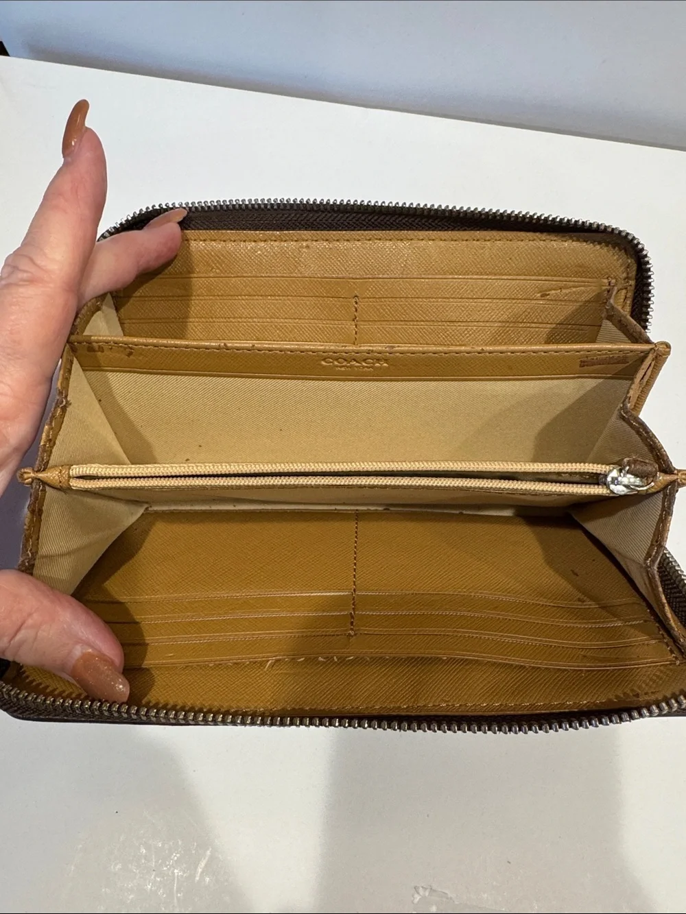 Coach Brown/Tan Signature Zip Wallet with Logo Plaque tags inside.
